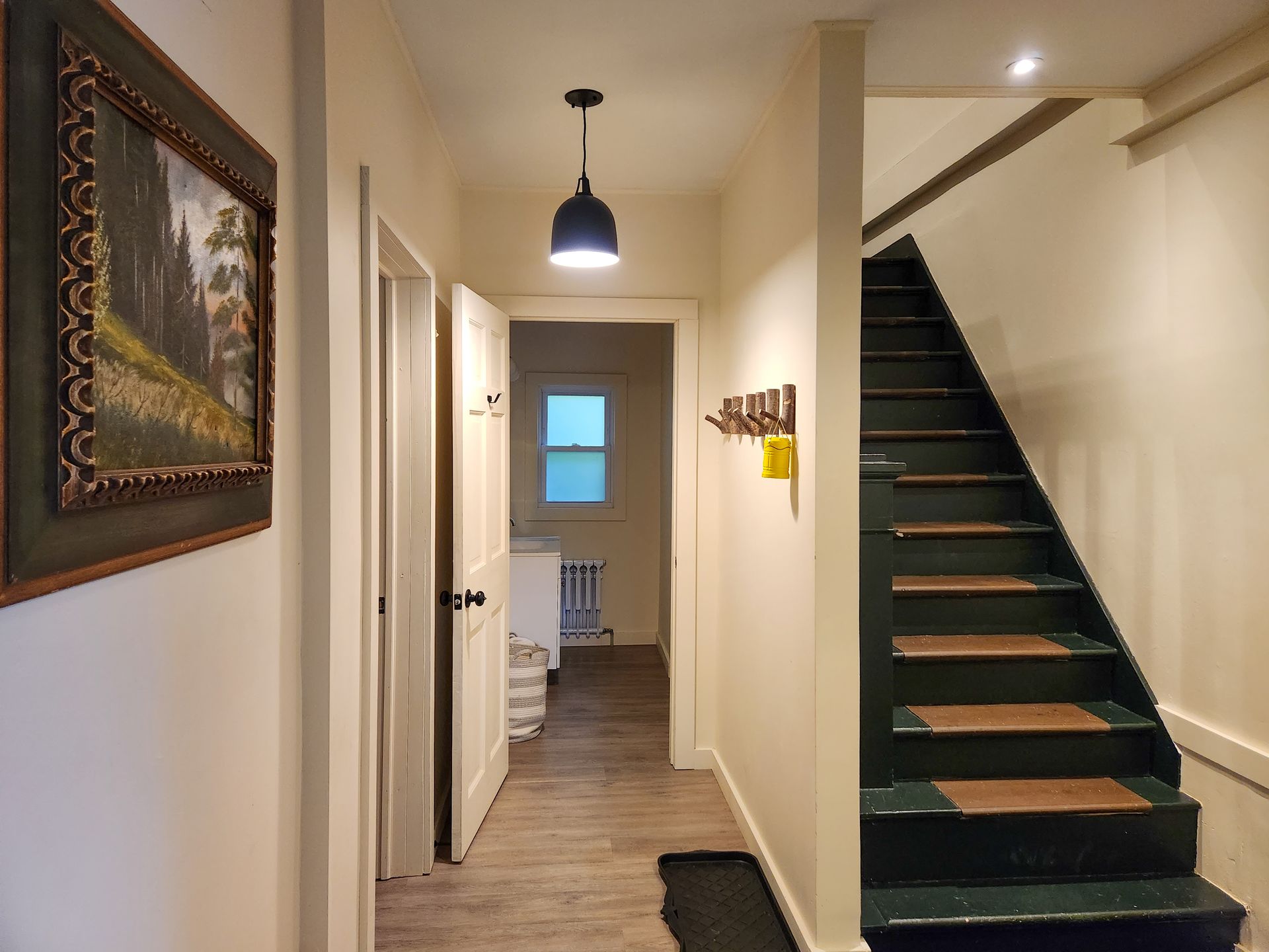 Hallway of Cabin #9 at Belleayre Lodge, showing stairs, walls, and decorative art on wall.