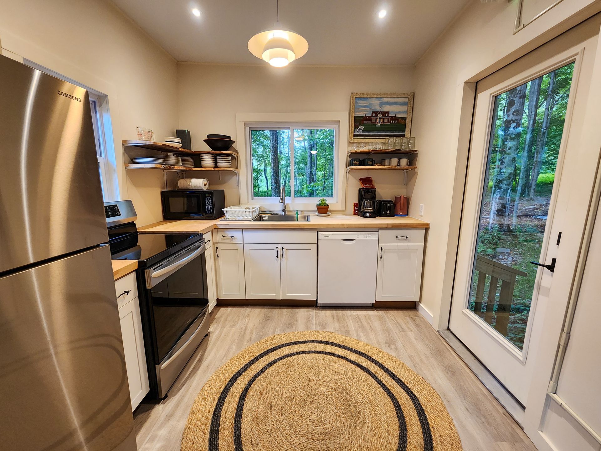 Kitchen of Cabin #9 at Belleayre Lodge, showing steel refrigerator, sink, stove, and kitchen appliances.
