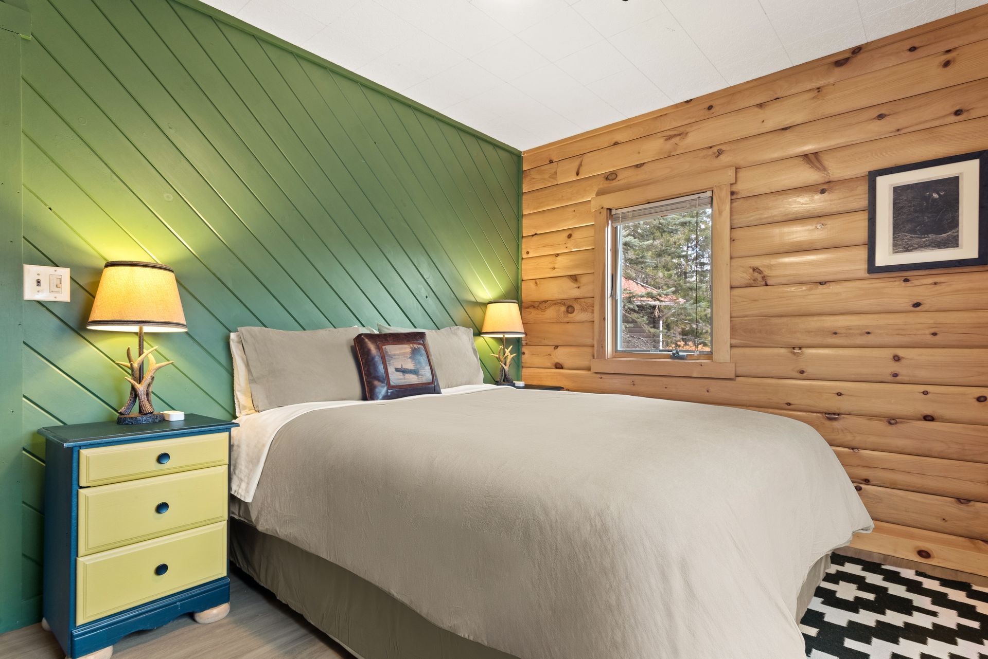 Cozy bedroom for Cabin 4A in Belleayre Lodge in Pine Hill, NY - showing comfortable bed, floral walls, and Catskill views