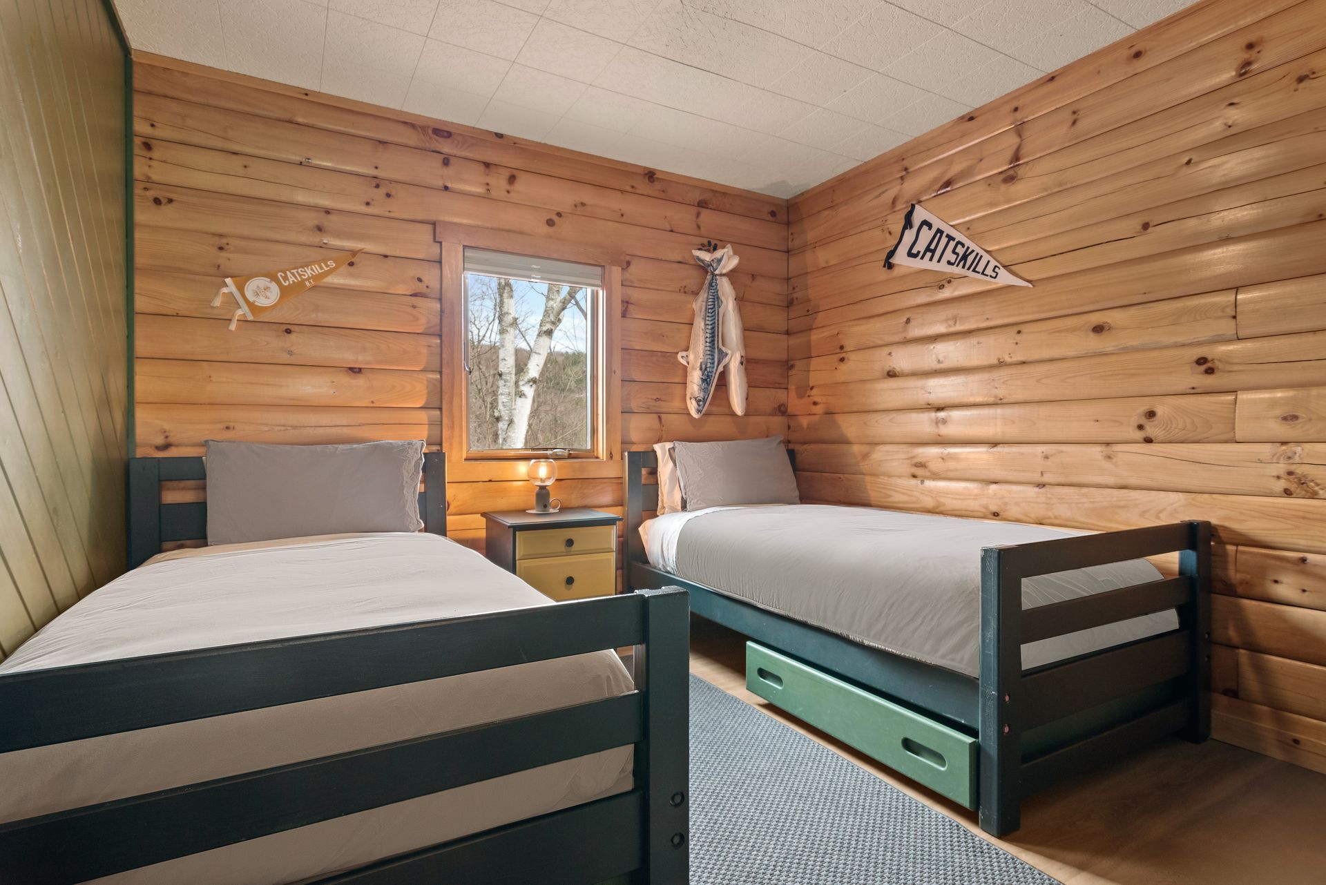 Cozy bedroom for Cabin 4A in Belleayre Lodge in Pine Hill, NY - showing two beds and Catskill views out the windows