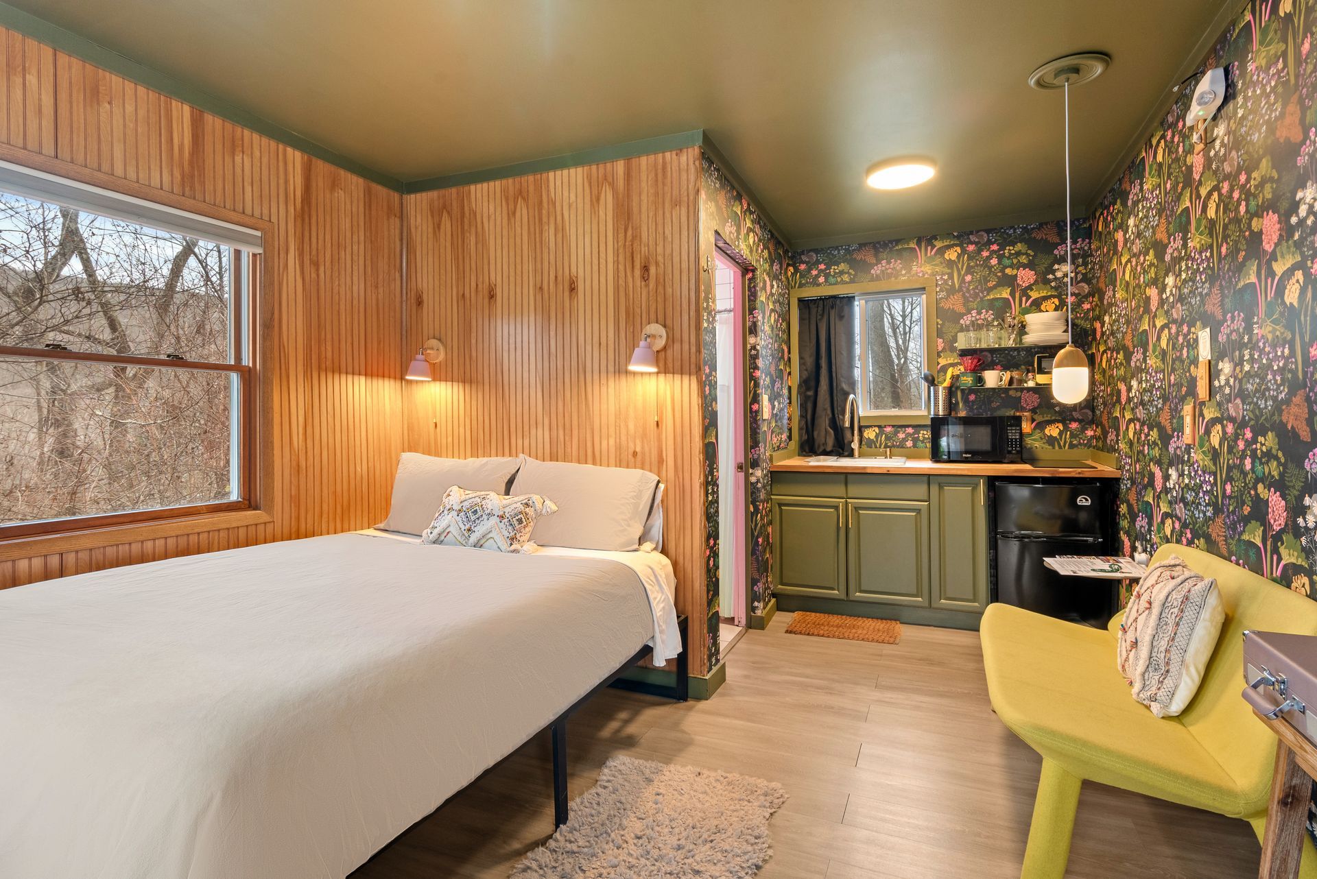 Cozy bedroom for Cabin 2 in Belleayre Lodge in Pine Hill, NY - showing comfortable bed, floral walls, and window views