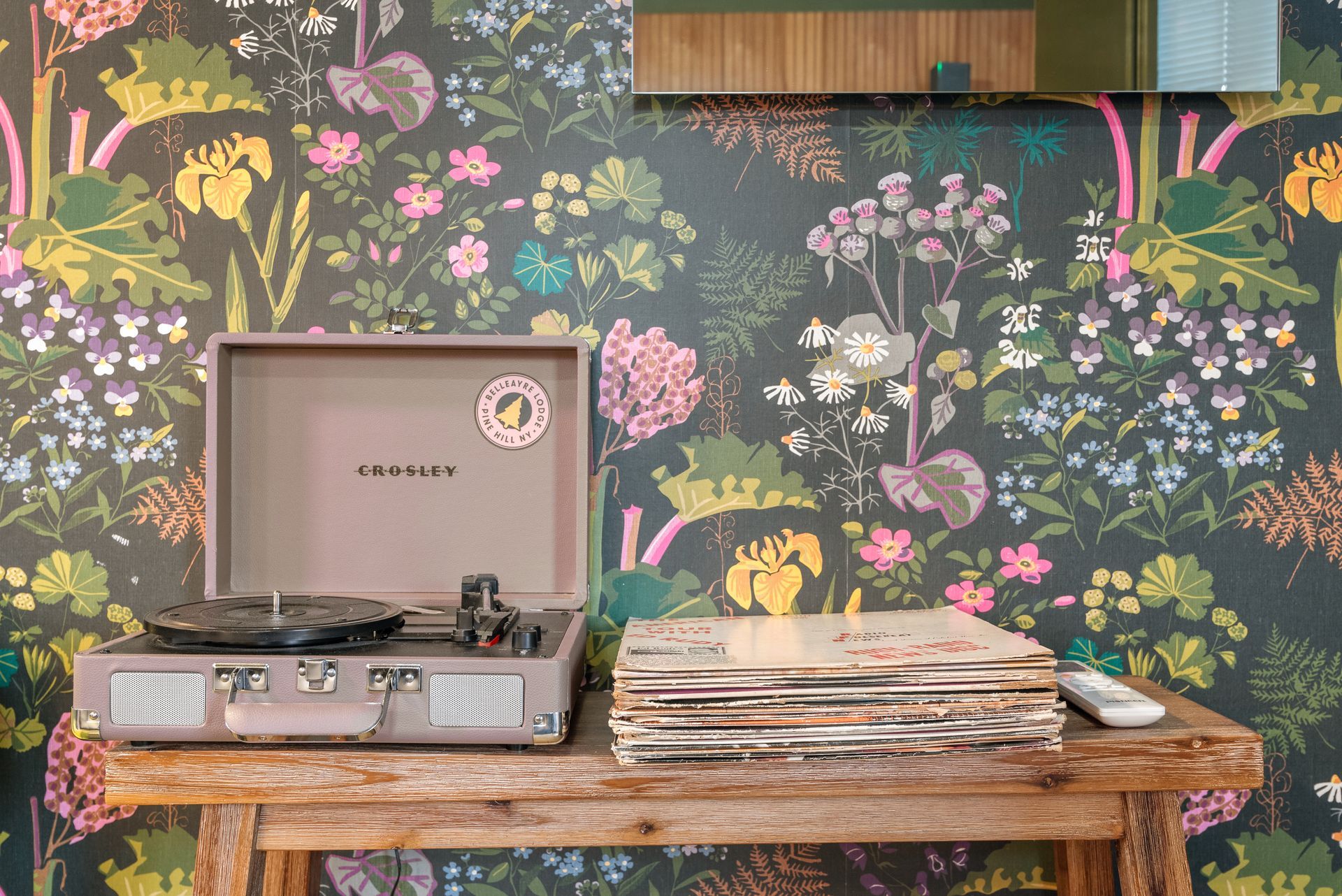 Cozy bedroom for Cabin 2 in Belleayre Lodge in Pine Hill, NY - showing Crossley vinyl record player, floral walls, and LP's
