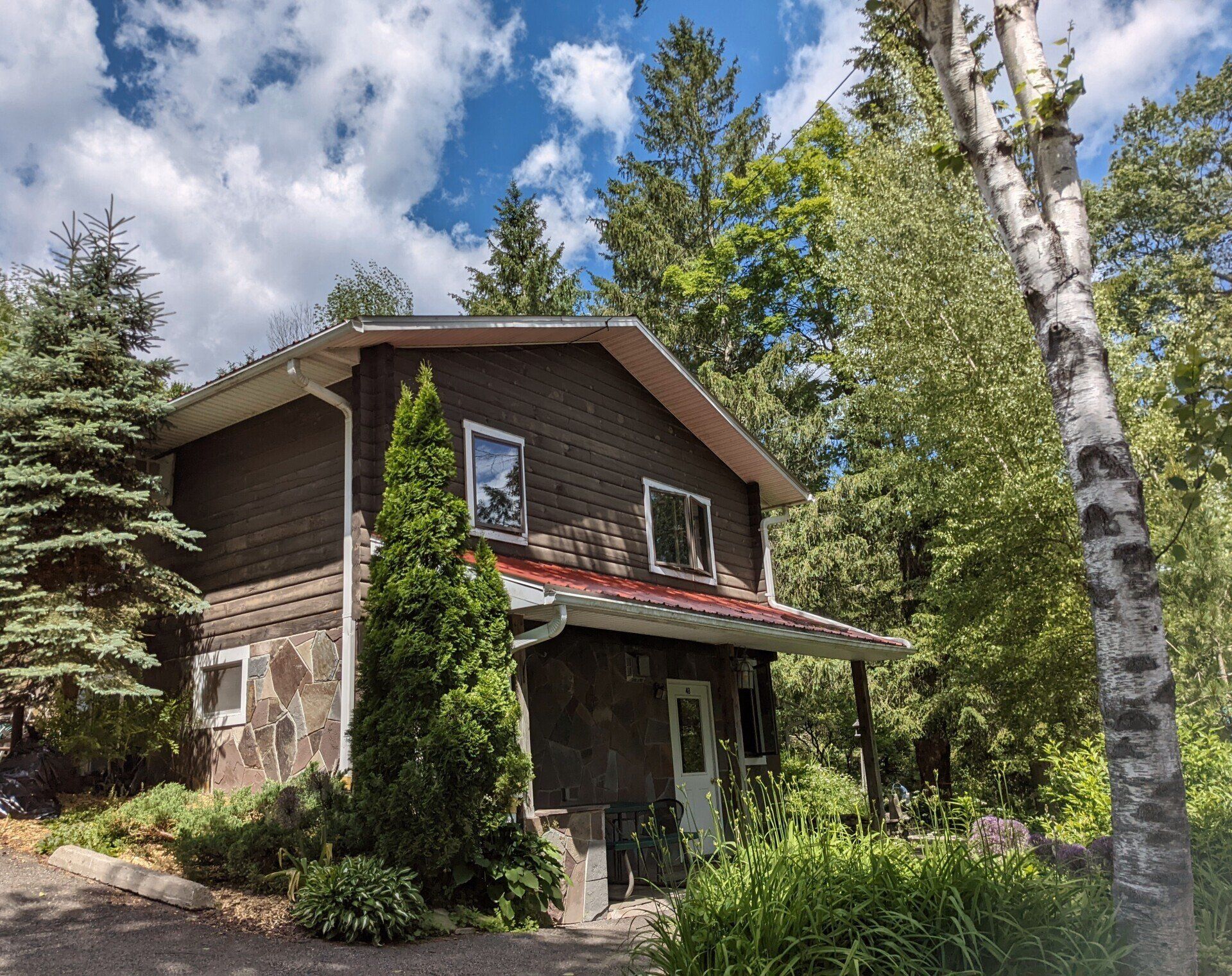 Exterior of Cabin 4B at Belleayre Lodge in the Catskills, NY, showing beautiful trees and foliage.