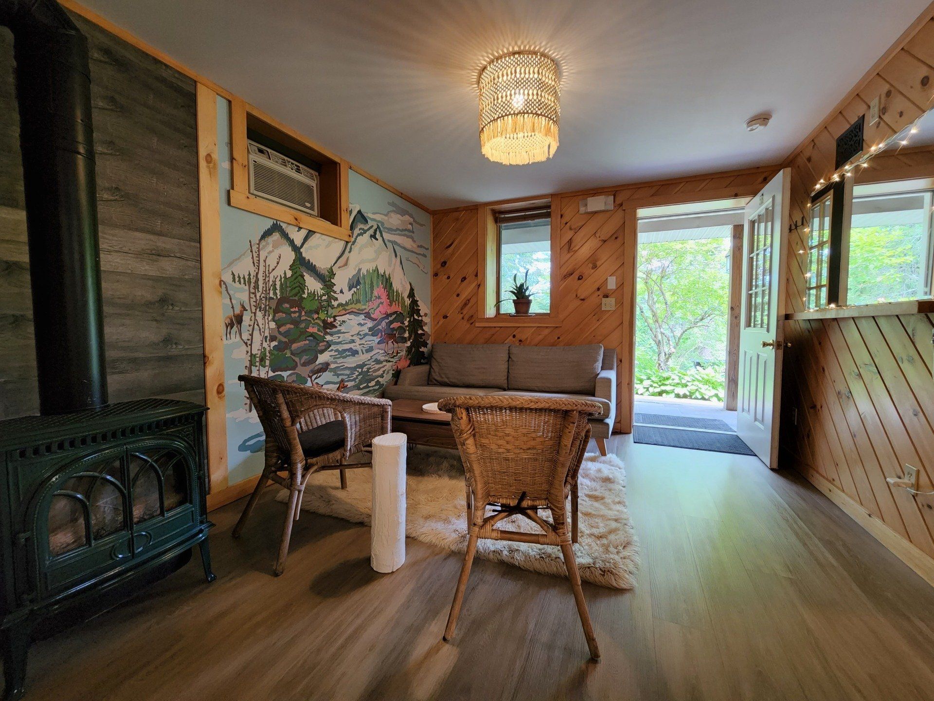 Living room space of Cabin #5B at Belleayre Lodge, showing sofas, chairs, and outdoor views of Catskills