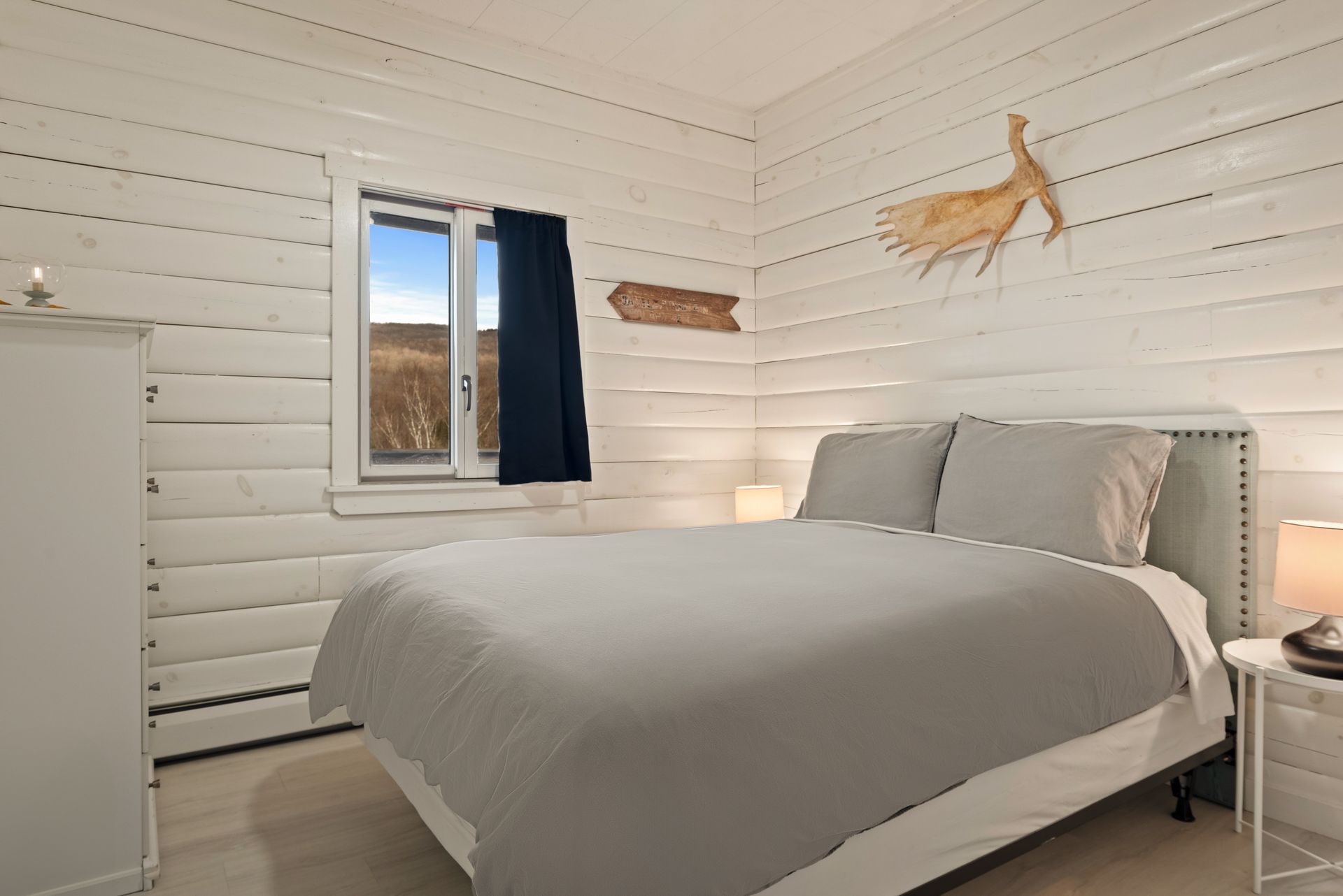 Cozy bedroom for Cabin 6 in Belleayre Lodge in Pine Hill, NY. Comfortable queen bed and beautiful Catskills views out window.