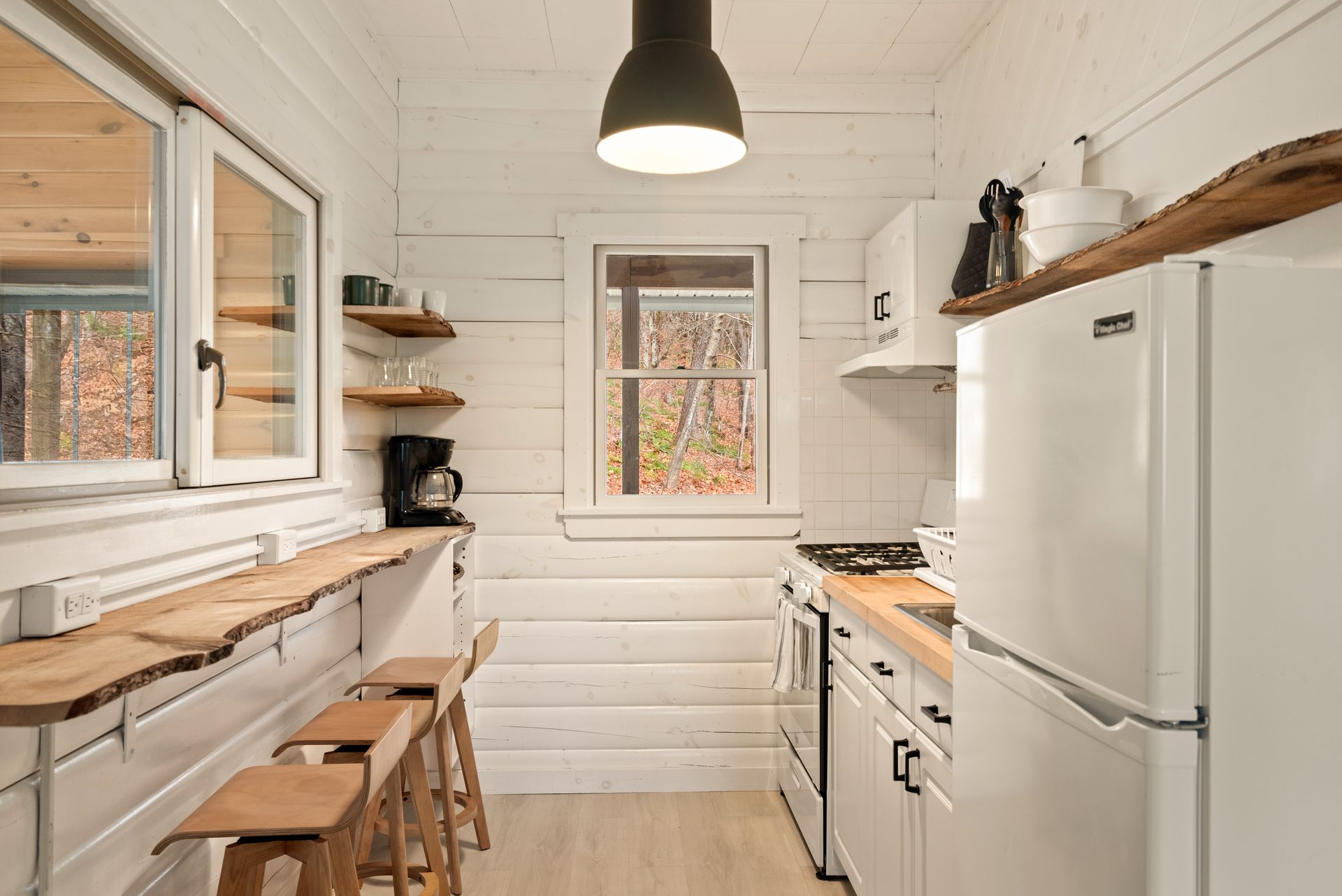 Cozy kitchen for Cabin 6 in Belleayre Lodge in Pine Hill, NY. Barstools, countertops, and kitchen appliances.