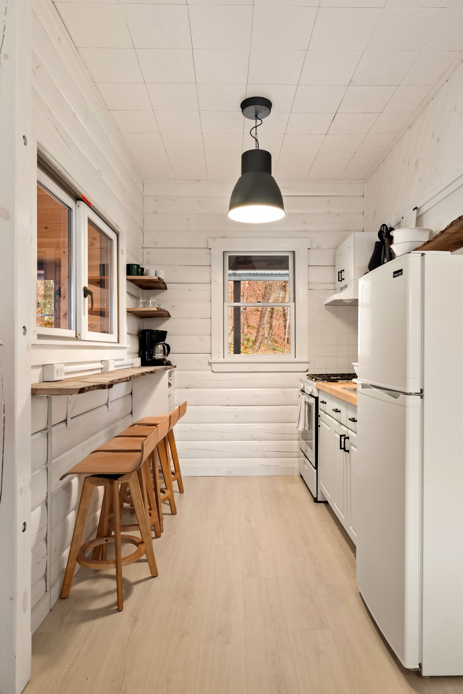 Cozy kitchen for Cabin 6 in Belleayre Lodge in Pine Hill, NY. Barstools, countertops, and kitchen appliances.