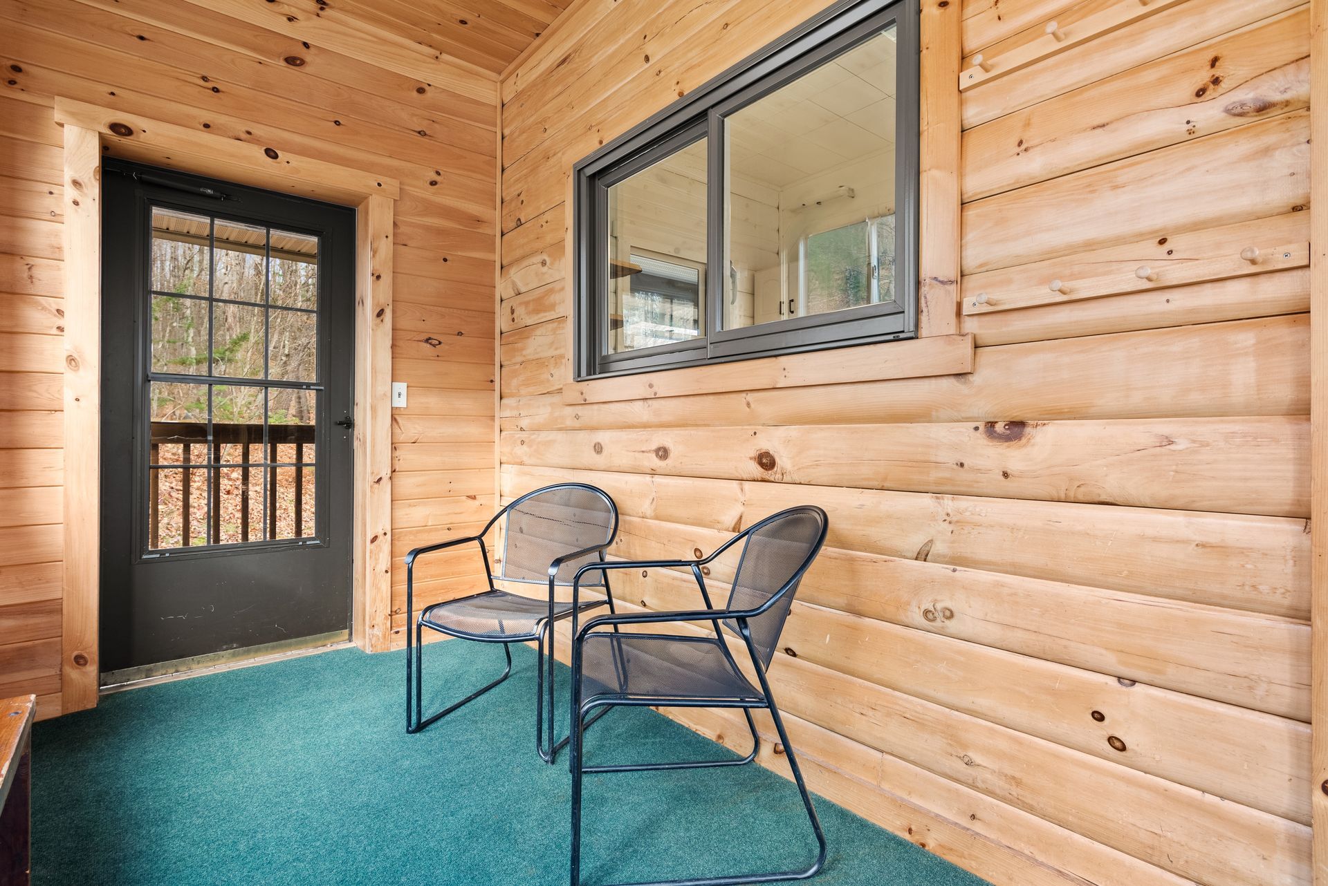 Cozy indoor dining for Cabin 6 in Belleayre Lodge in Pine Hill, NY. Wooden table and benches in front of beautiful view.