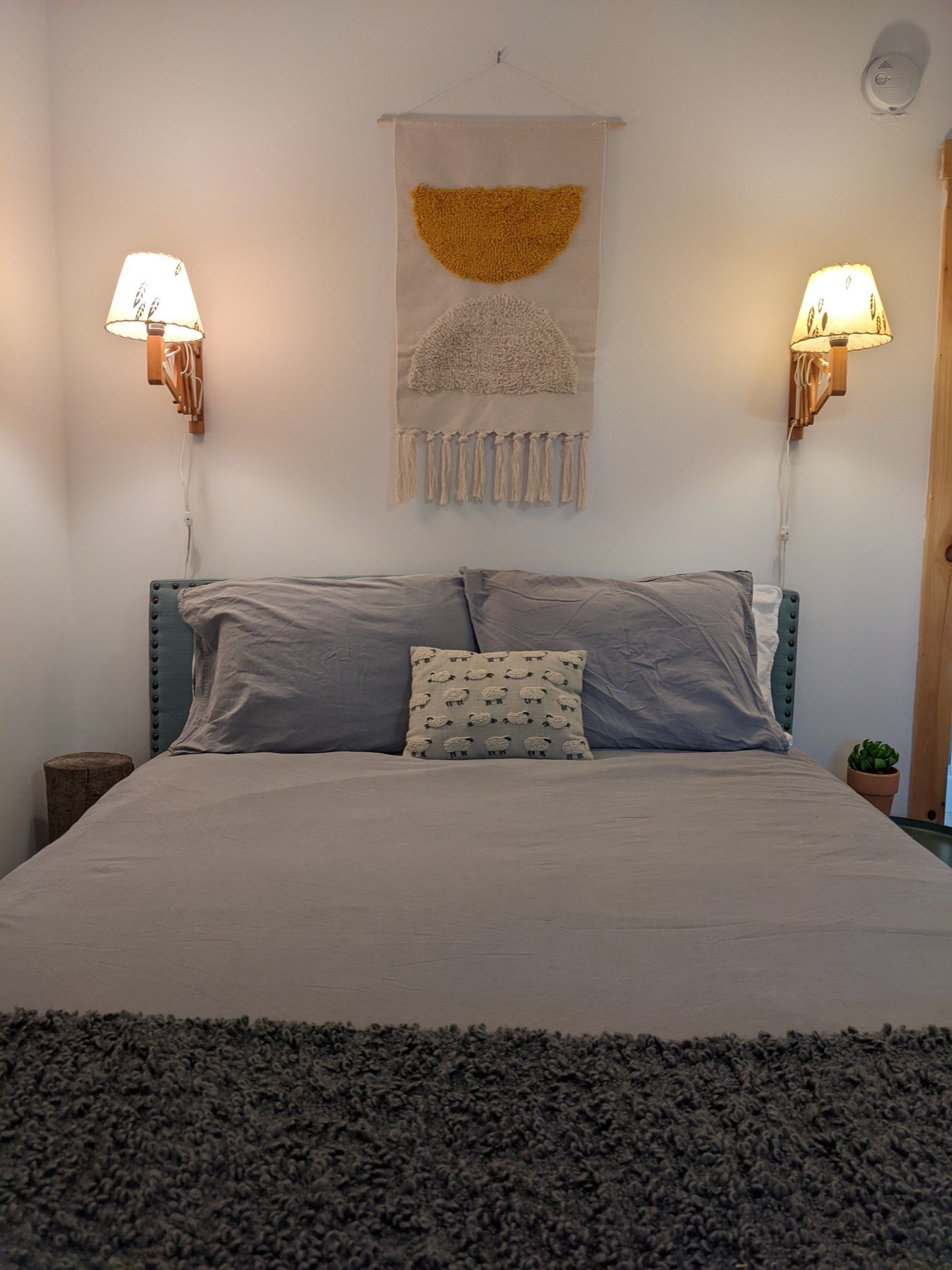 Cozy queen bed in bedroom of Cabin #8 at Belleayre Lodge in Catskills, NY.