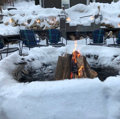 Firepit with bonfire, surrounded by chairs, at Belleayre Lodge in Pine Hill New York