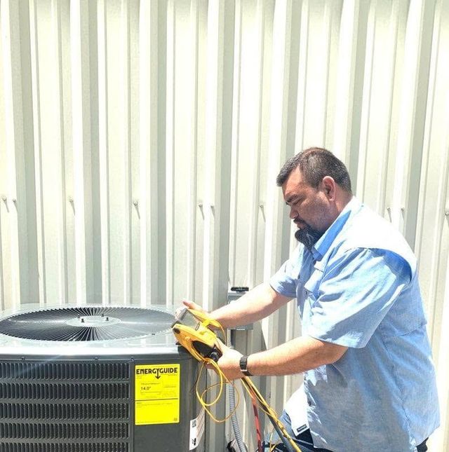 Technician inspecting a large HVAC unit with a yellow handheld tool indoors