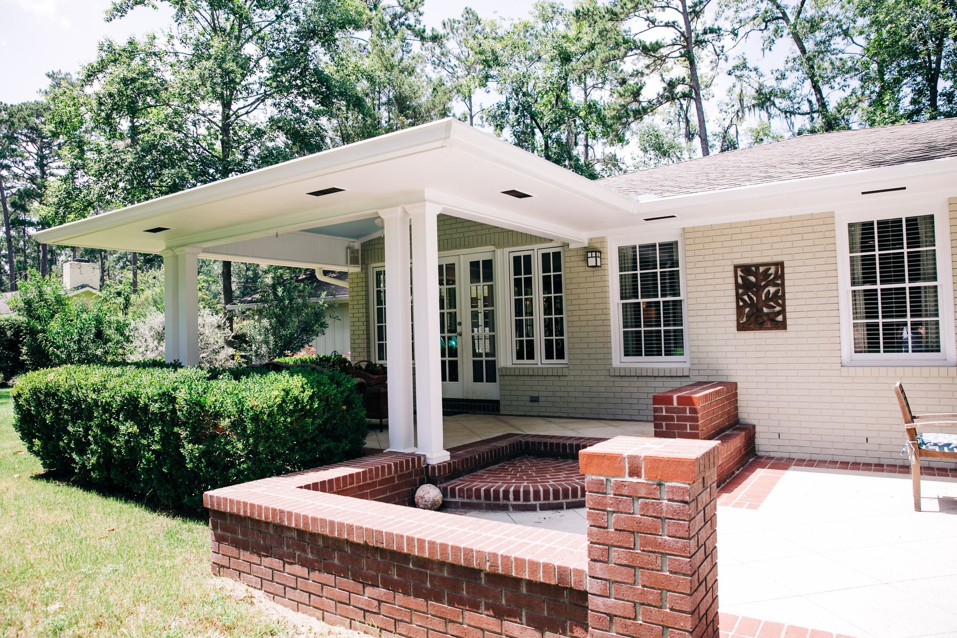 A white house with a brick patio in front of it