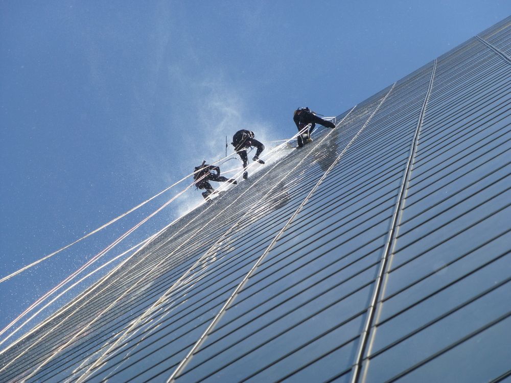 A Group of People Are Climbing Up the Side of a Building — Dazzling Windows & Pressure Cleaning in Currumbin, QLD