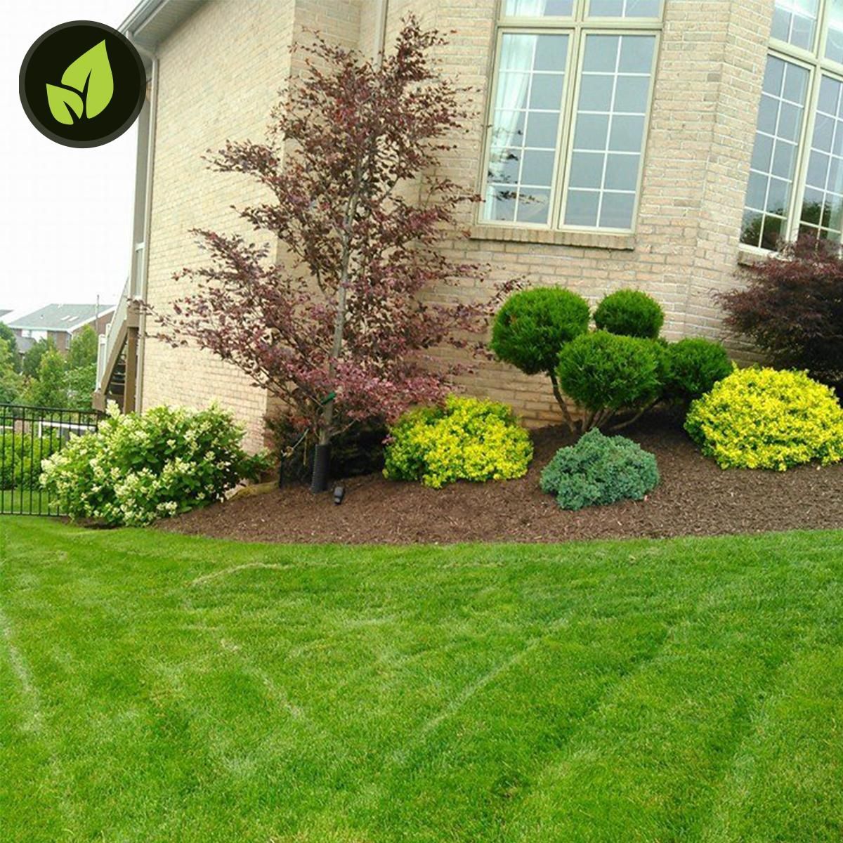 Curved retaining wall made of tan blocks, edging a flower bed and green lawn.