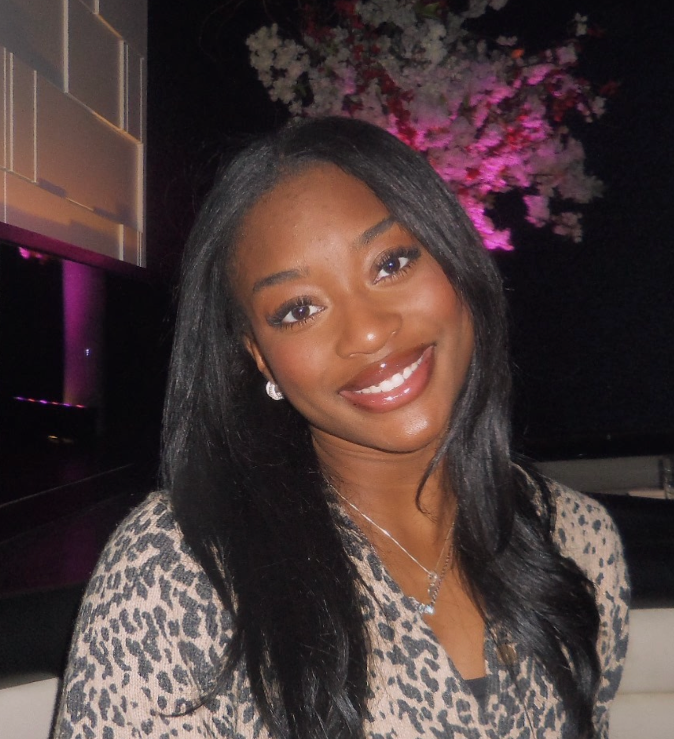 A woman in a leopard print shirt smiles for the camera