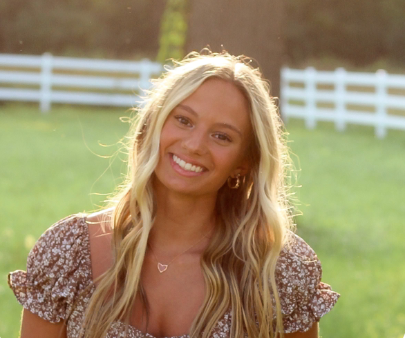 A woman in a bikini is smiling and looking at the camera.