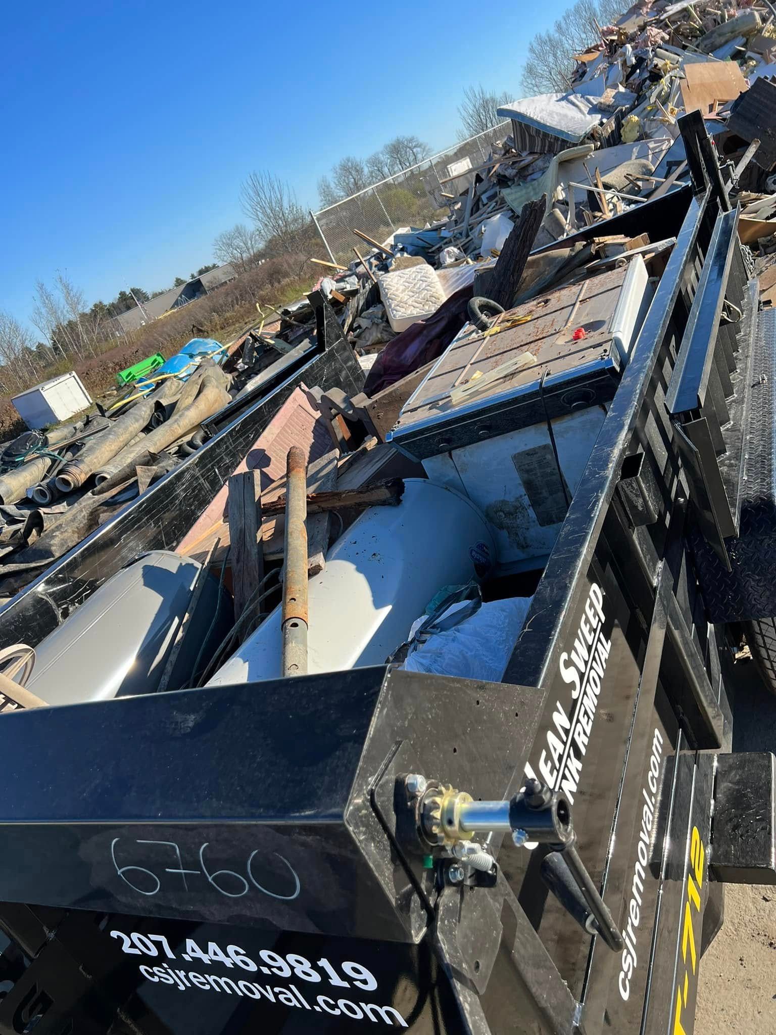 Damaged debris-filled machinery at a junkyard under a clear blue sky