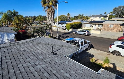 View of rooftops and street in a residential neighborhood on a sunny day.