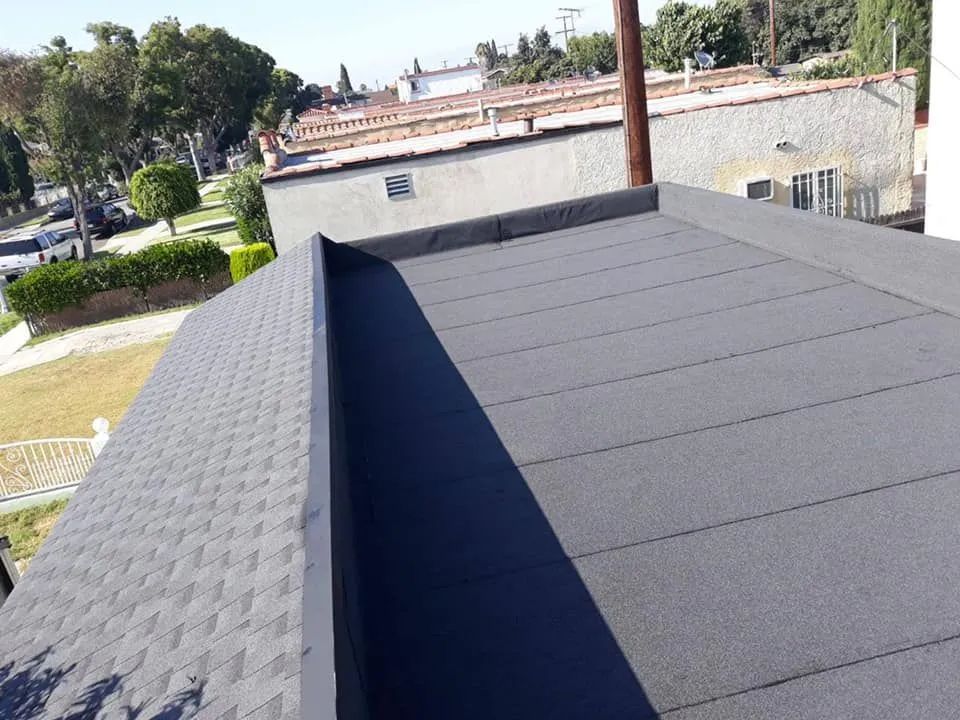 Flat dark roof with a raised ridge, viewed from above in a suburban neighborhood