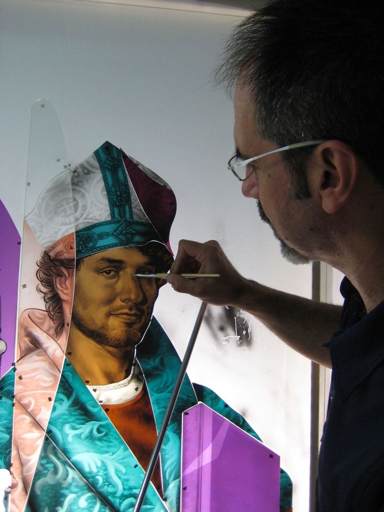 Artist painting a portrait on a wall mural with bright teal and purple colors