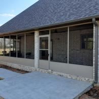 Modern brick house exterior with covered porch and concrete patio