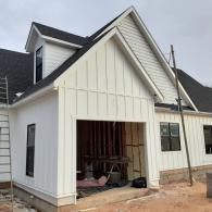 White house under construction with an open front entry and unfinished siding