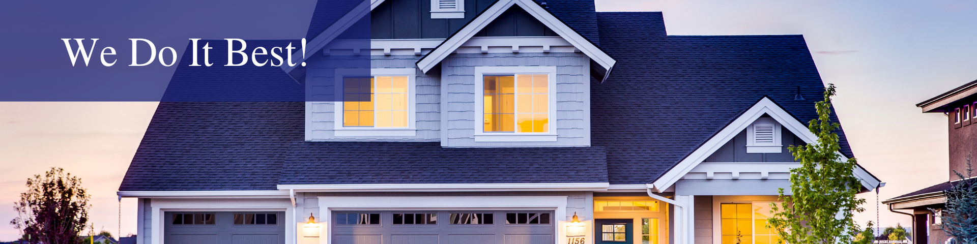 House exterior with a blue-gray roof and lit windows, with the text “We Do It Best!” in the corner