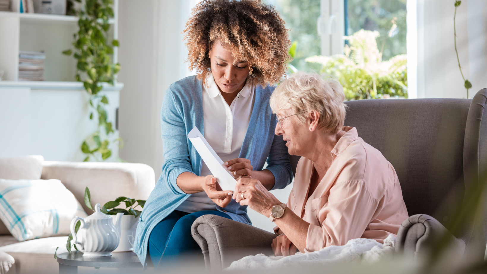 a woman is sitting on a couch talking to an older woman .