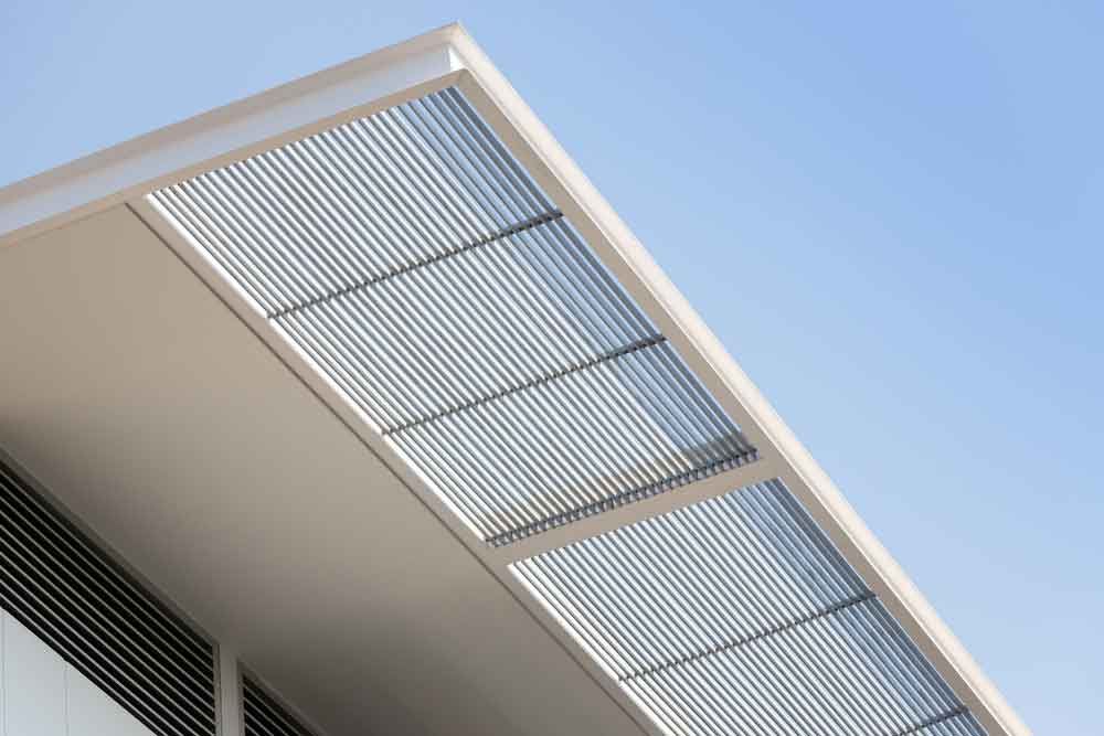 Metal Louvre Awnings Against Blue Sky — Blinds in Bogangar, NSW