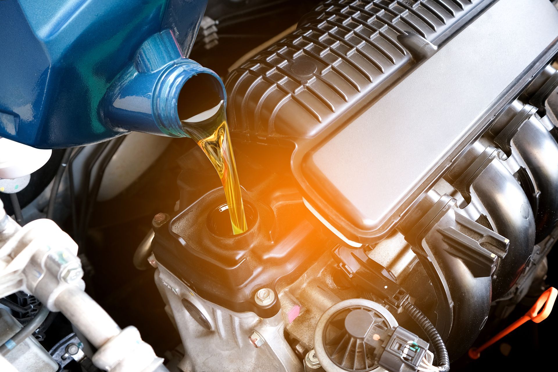 A Person is Pouring Oil Into a Car Engine