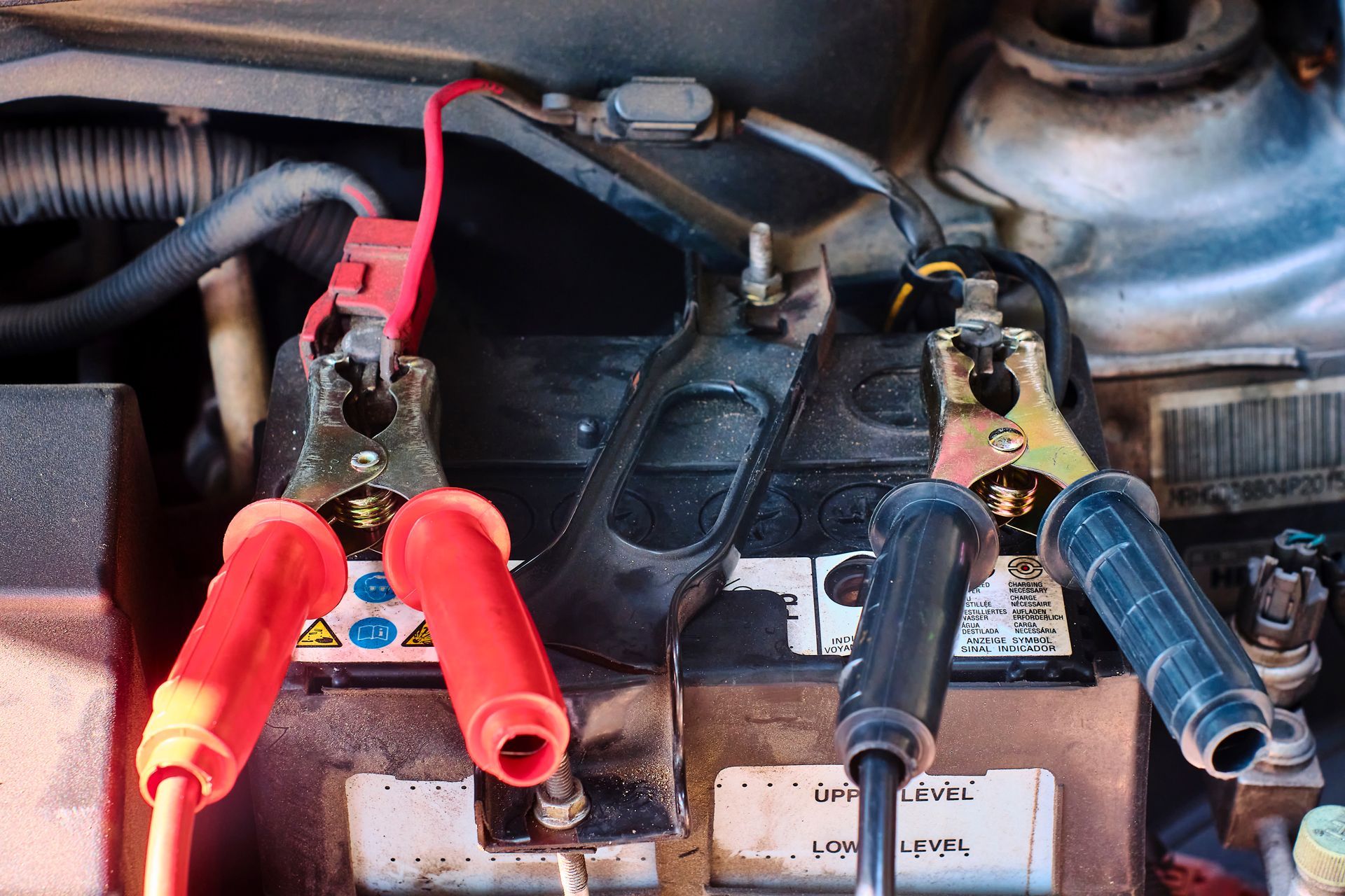A Close Up of a Car Battery With Jumper Cables Attached to It
