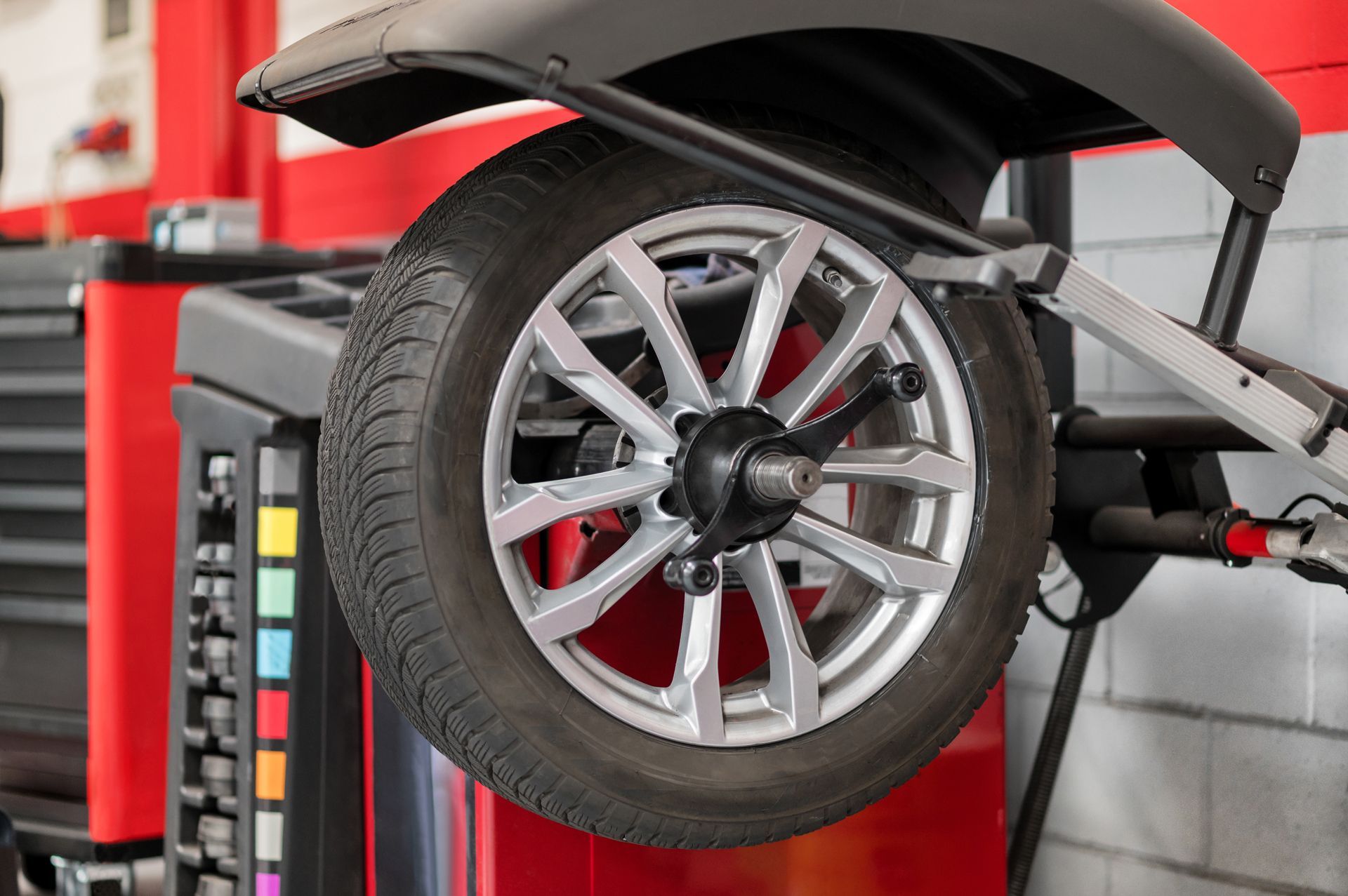 A Car Wheel is Being Balanced on a Machine in a Garage