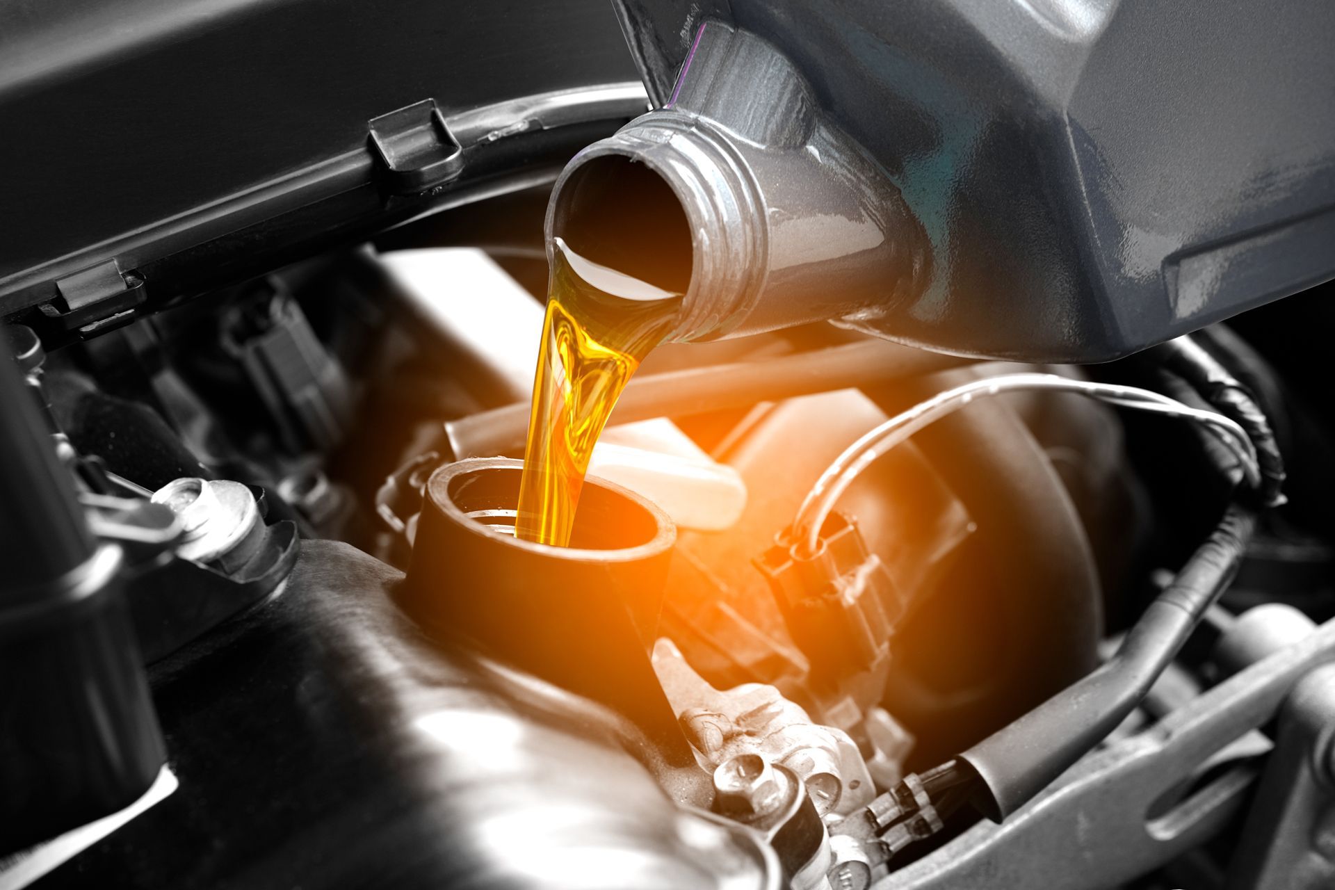 A Close Up of a Person Pouring Oil Into a Car Engine