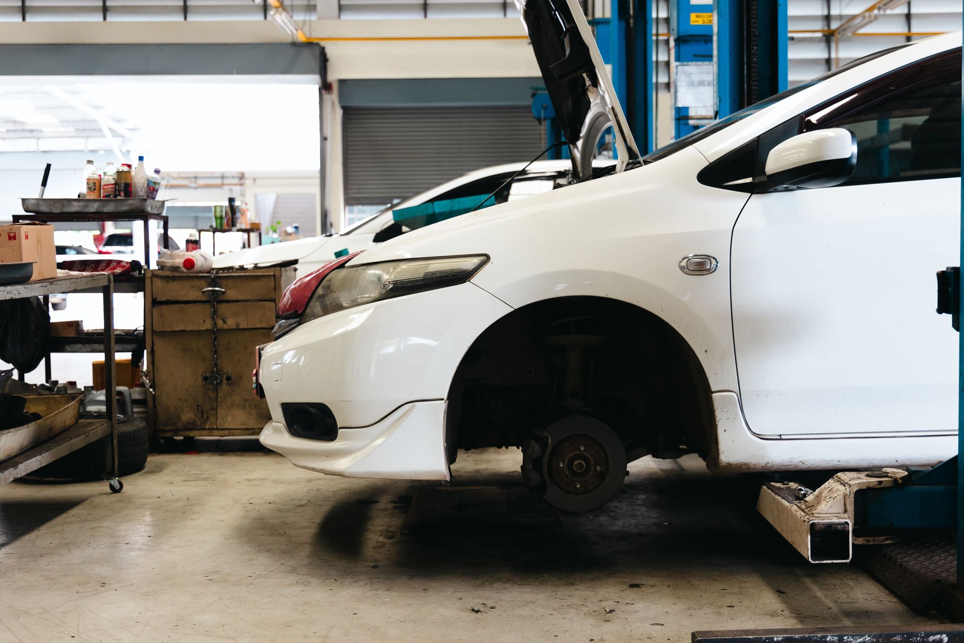 A White Car is Sitting on a Lift in a Garage