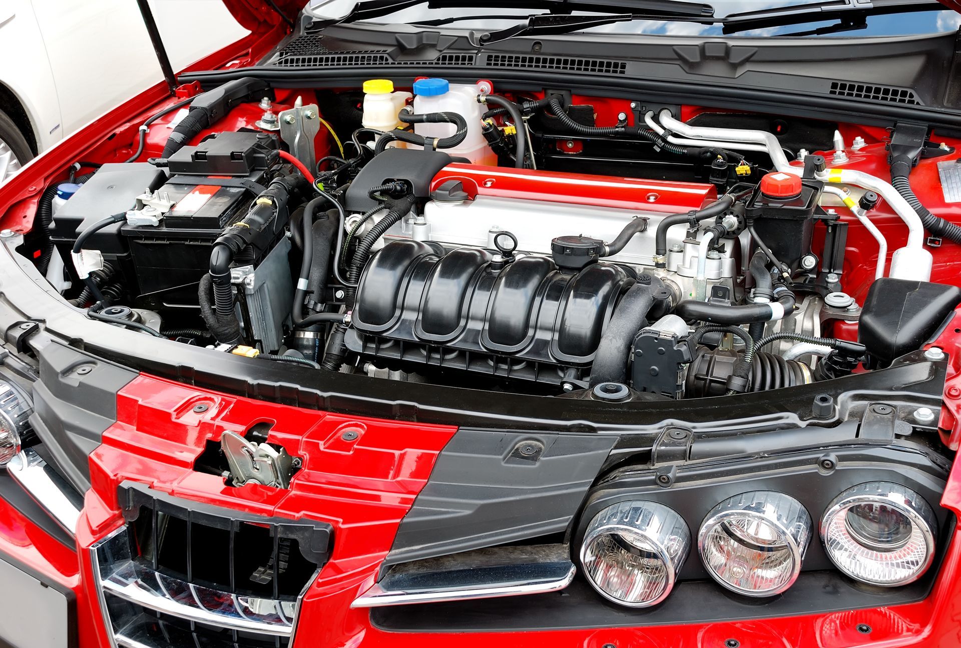The Engine of a Red Car is Visible Under the Hood