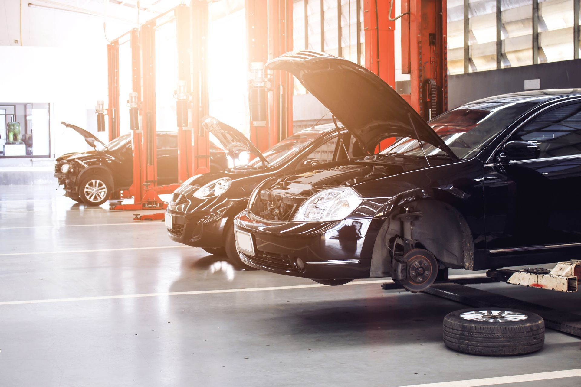 A Row of Cars Are Parked in a Garage With Their Hoods Open