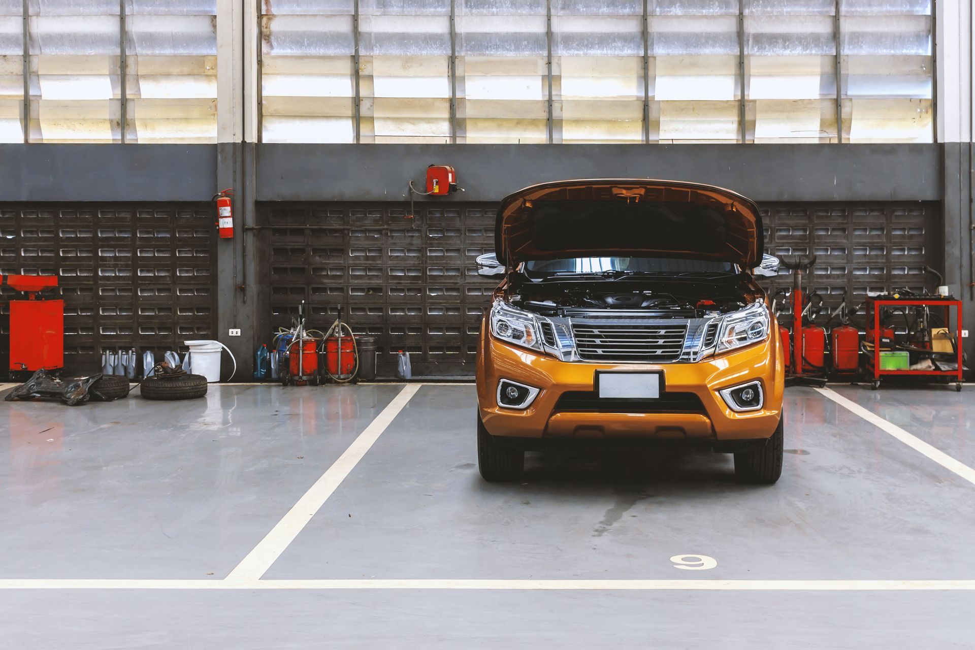 A Car is Parked in a Garage With the Hood Up