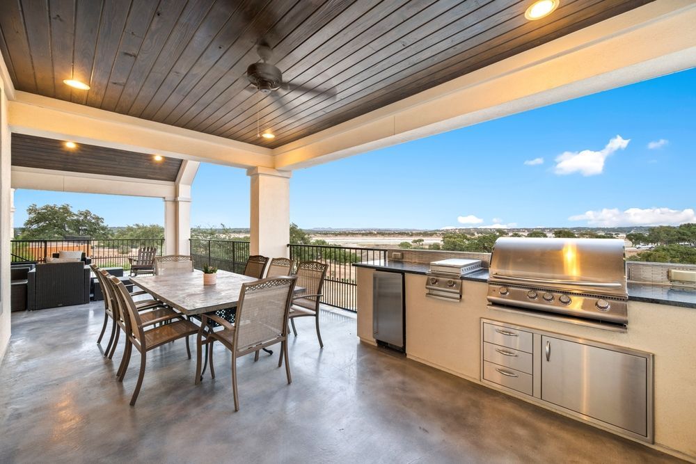 A patio with a table and chairs and a grill.