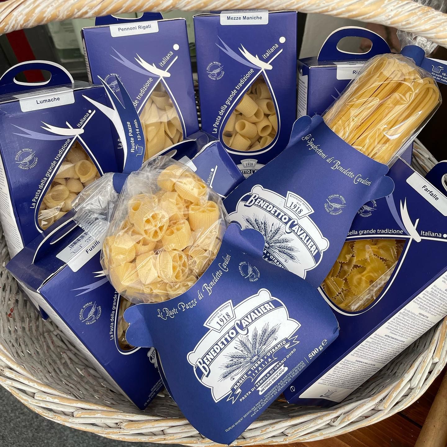 Un cestino pieno di diversi tipi di pasta tra cui i rigatoni