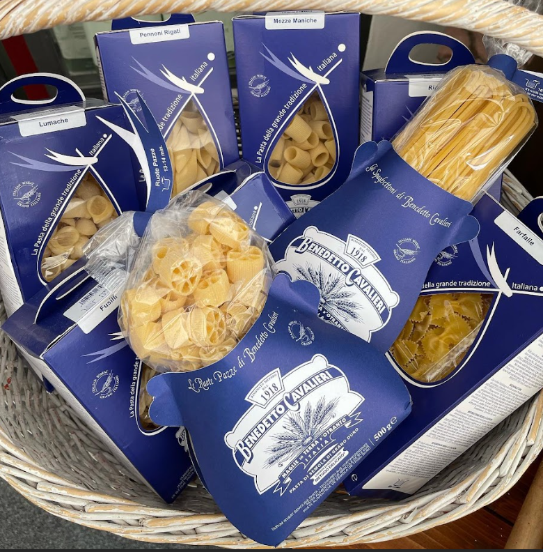Un cestino pieno di diversi tipi di pasta, compresi gli spaghetti