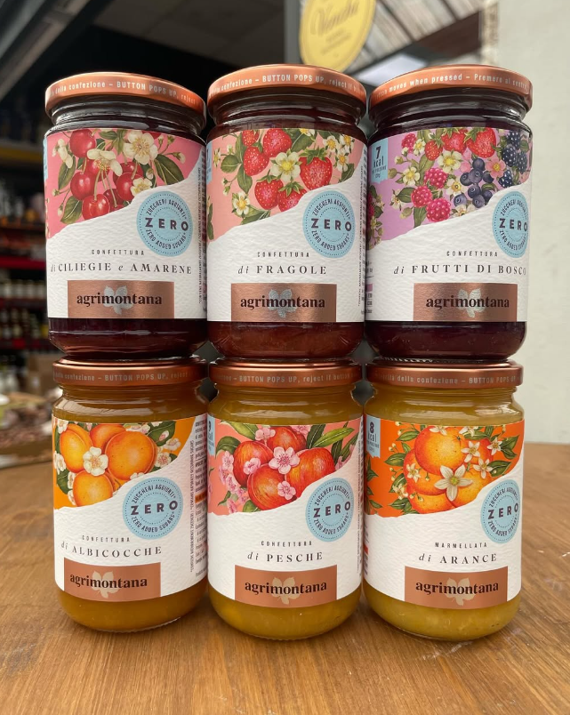 Sei barattoli di marmellata sono impilati uno sopra l'altro su un tavolo di legno.