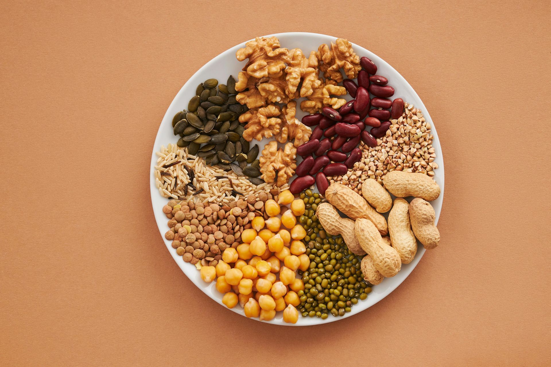Ci sono molti tipi diversi di noci e fagioli nel piatto.