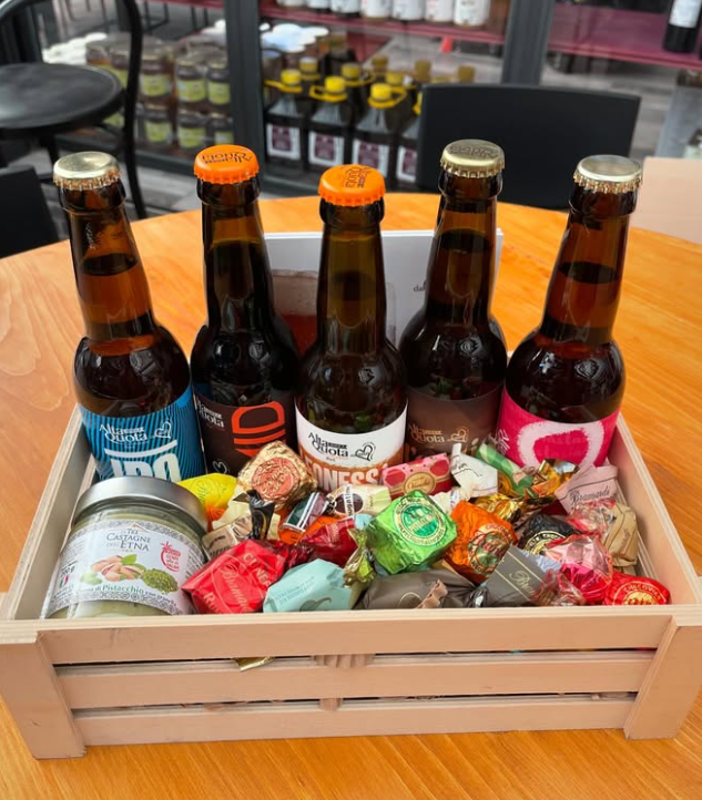 Una scatola di legno piena di bottiglie di birra e caramelle