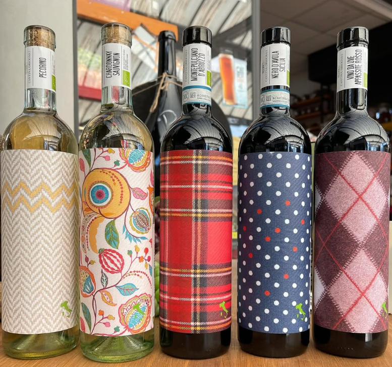 Una fila di bottiglie di vino con disegni diversi su di esse