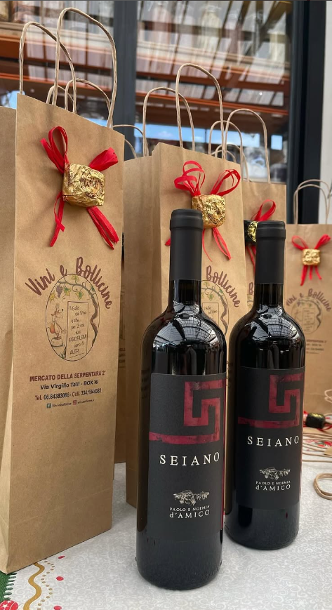 Due bottiglie di vino sono appoggiate una accanto all'altra su un tavolo.