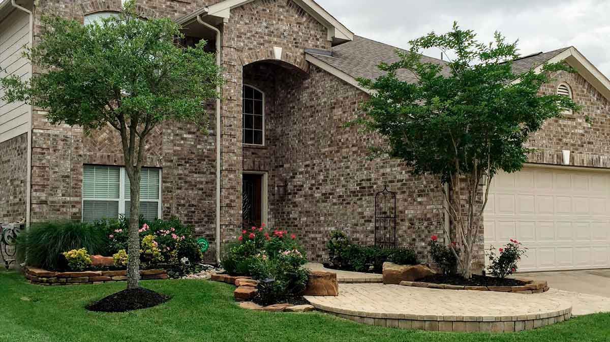 Elegant landscaping design with flowers and yellow brick pathway