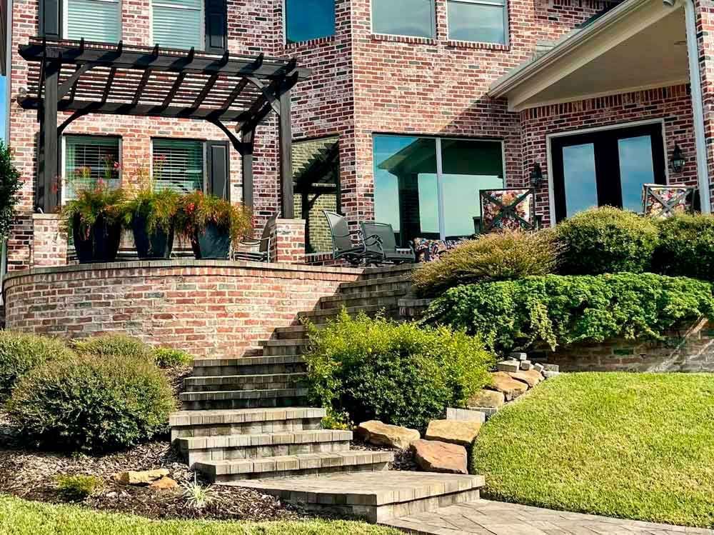 An outdoor living space with a pergola and paver steps