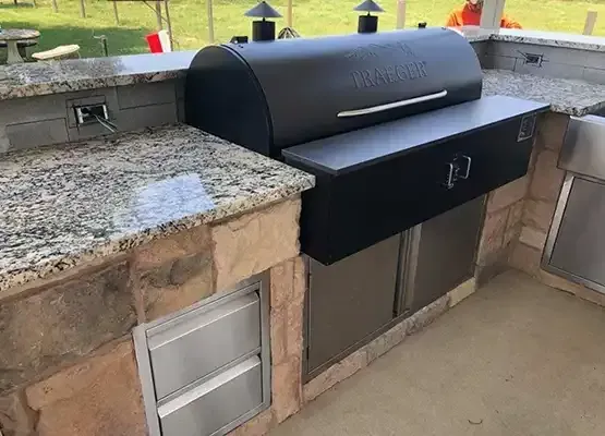 a grill is sitting on top of a granite counter in a kitchen .