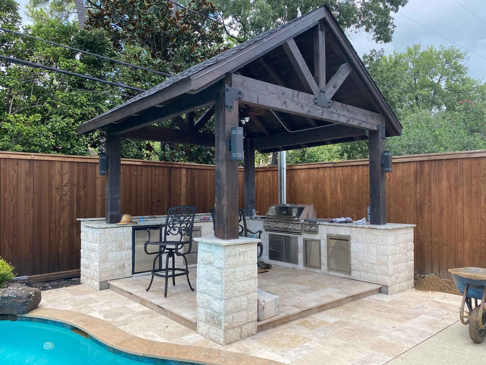 Outdoor pergola with custom kitchen and paver deck