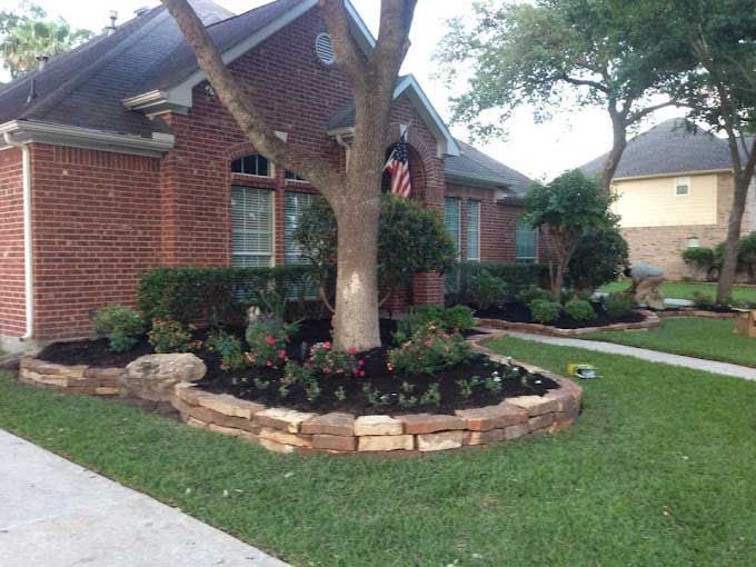 Nice circular stone landscaping bed with tree and flowers